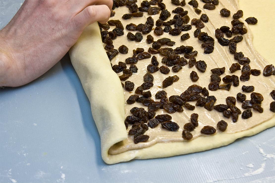 starting to roll up the dough and filling