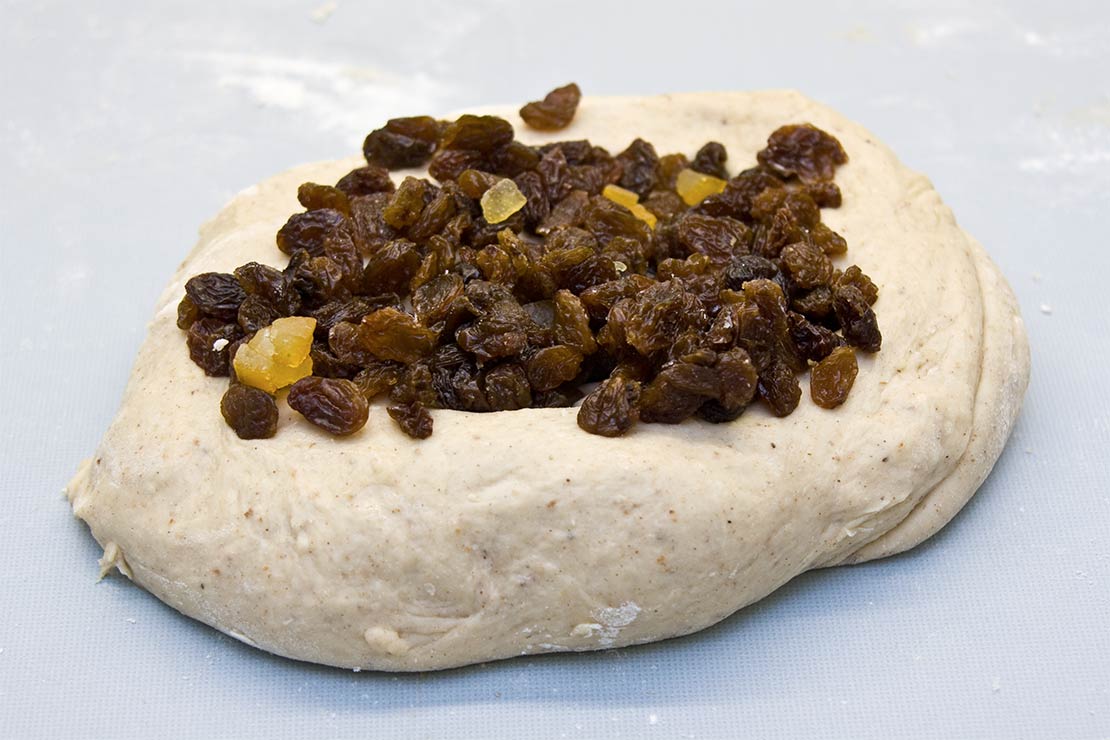adding the fruit to the hot cross bun dough
