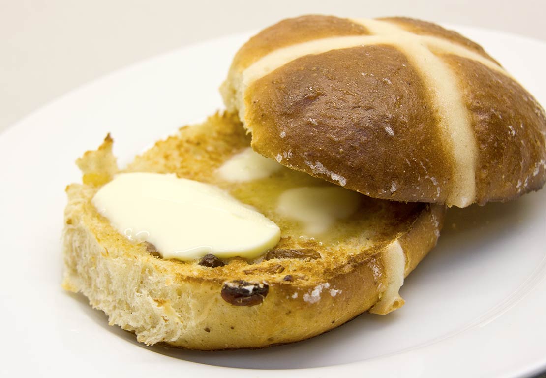 a finished, toasted hot cross bun with butter
