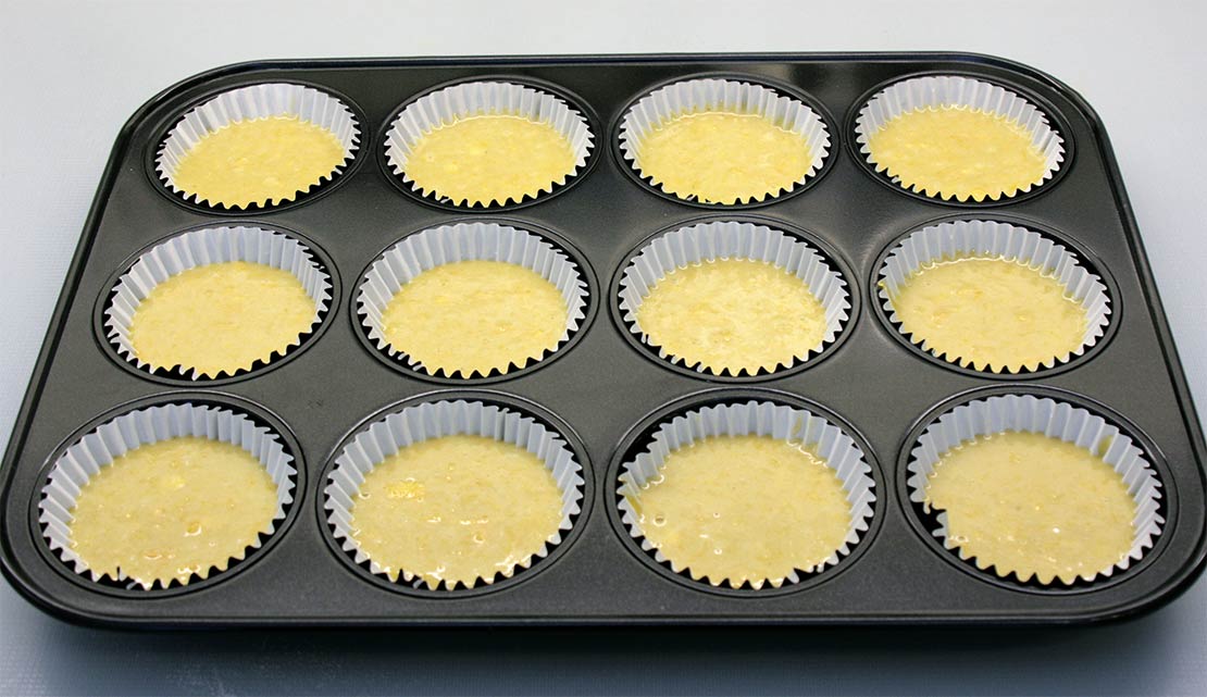 the cake batter in the paper cases