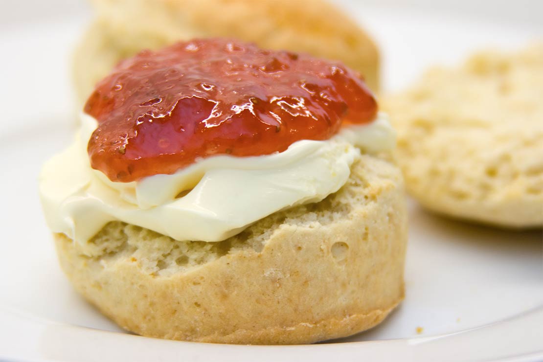 a finished scone with clotted cream and strawberry jam