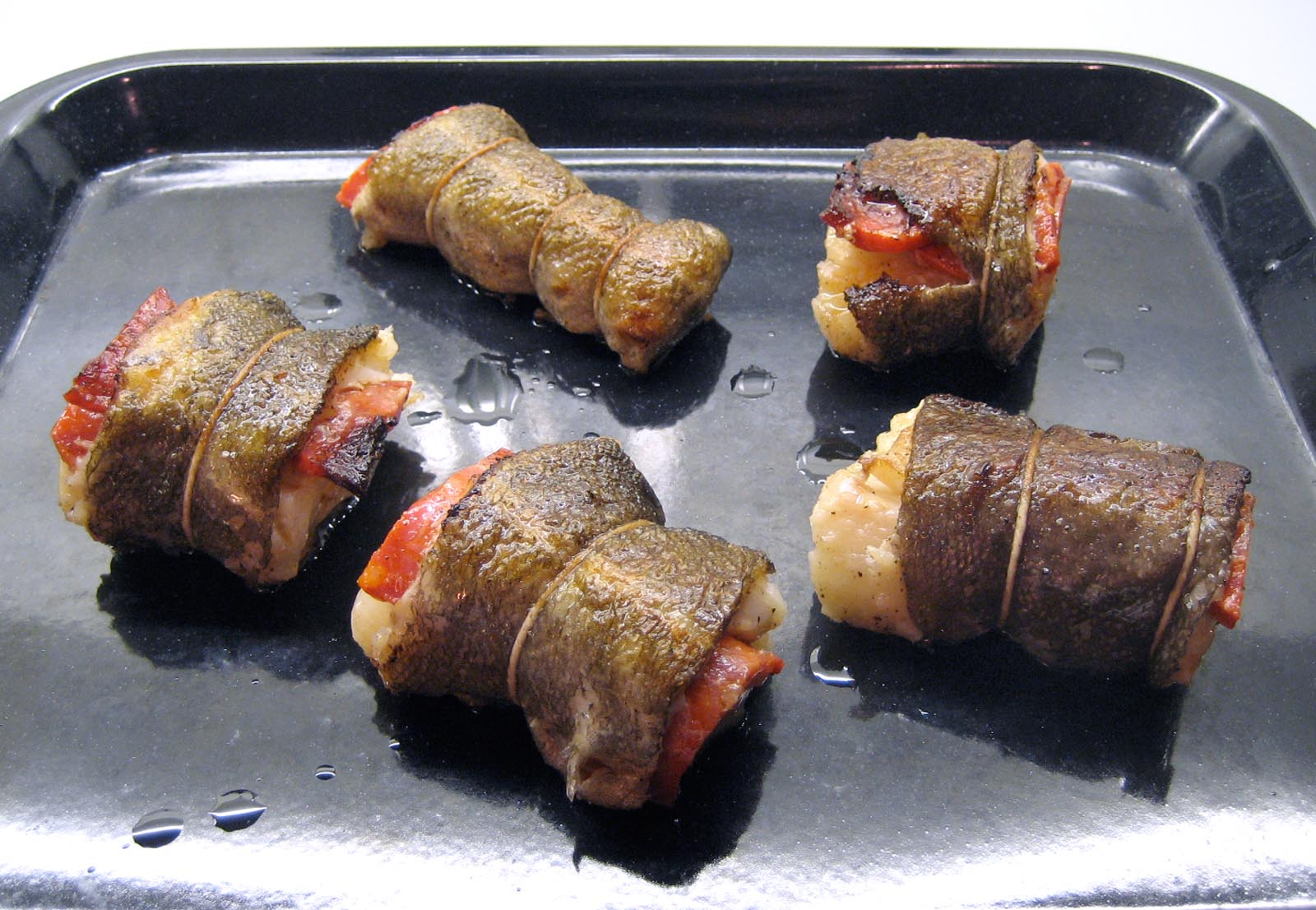 the fried, portioned cod on a baking tray