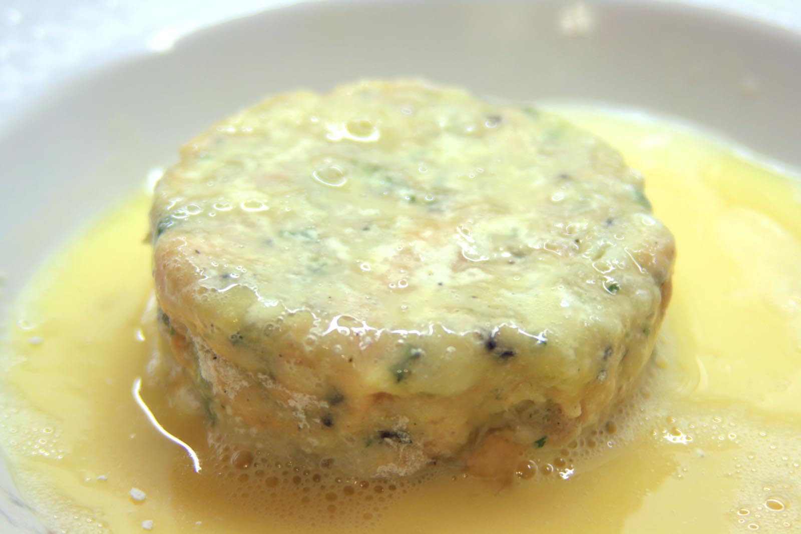 coating the fish cakes in the beaten egg
