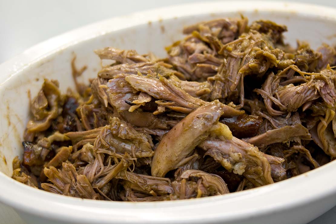 mixing the shredded duck with the reduce sauce