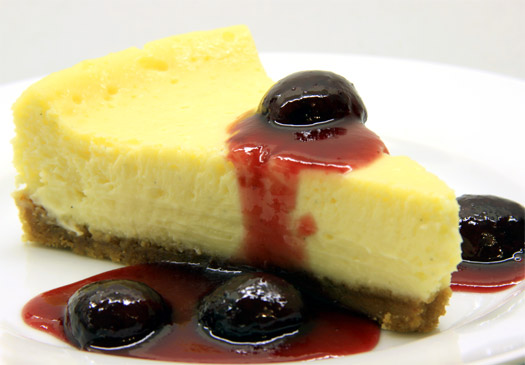 a slice of the finished baked cheesecake with cherry compote