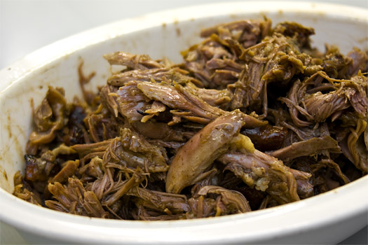 mixing the shredded duck with the reduce sauce