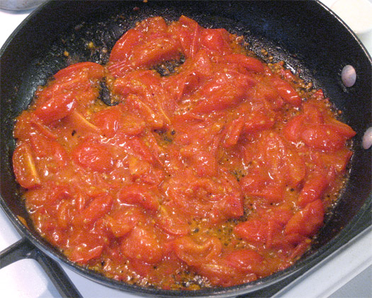 cooking the tomato and chilli in a frying pan